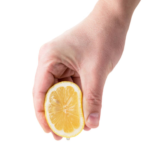istock Male hand squeezes lemon juice on a white, isolated. 1149885171