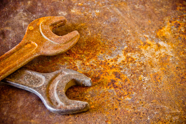 Group of old rusty metal mechanic tools lying on a concrete surface