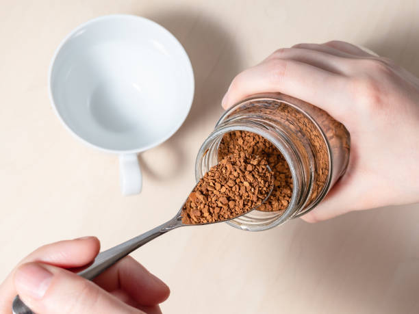 istock female hand spooning up instant coffee from jar 1149889549