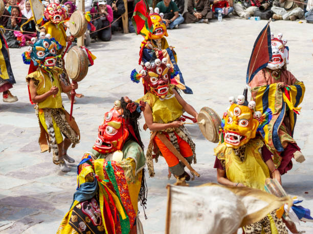 monjes no identificados en máscaras con tambores lleva a cabo una danza religiosa enmascarada y disfrazado de misterio del budismo tibetano tántrico en el festival de danza cham en el monasterio de hemis, linaje drukpa de la escuela kagyu - cham mask fotografías e imágenes de stock