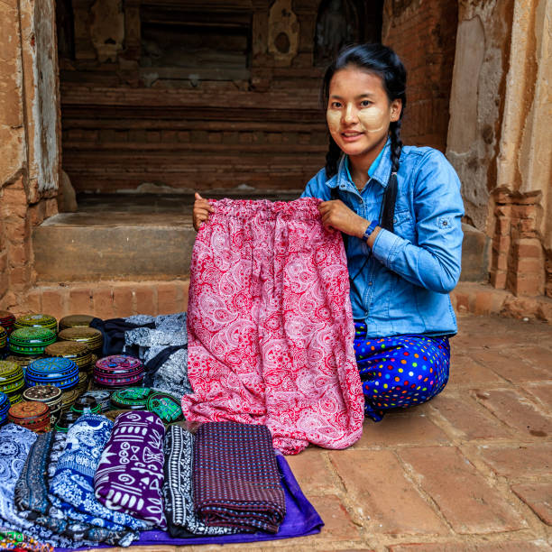 istock Young Burmese girl selling a longyi and lacquerware in Bagan, Myanmar 1149896470