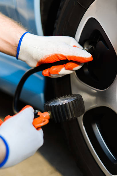 istock driver checking air pressure in the tires close up 1149896817
