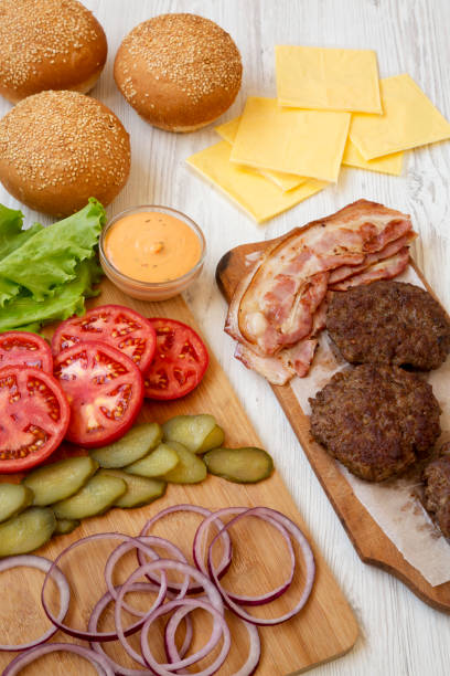 istock Burger ingredients on a white wooden background, side view. Close-up. 1149897841