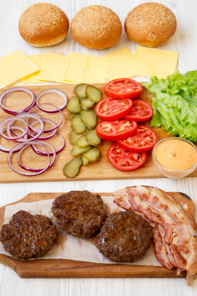 istock Burger ingredients on a white wooden surface, side view. Close-up. 1149897897