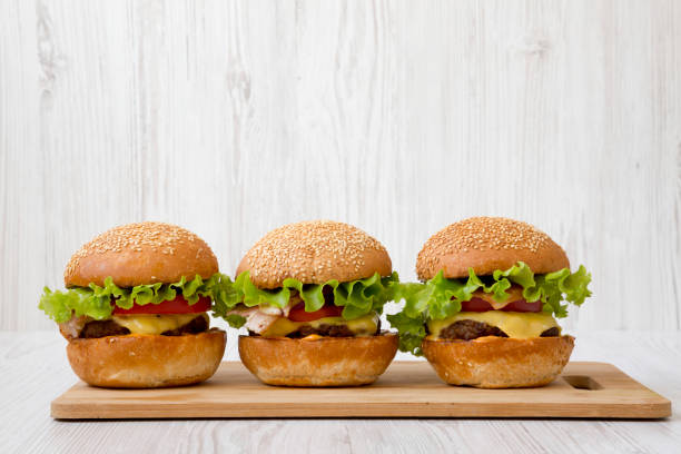 istock Homemade cheeseburgers on a bamboo board, side view. Close-up. 1149898500