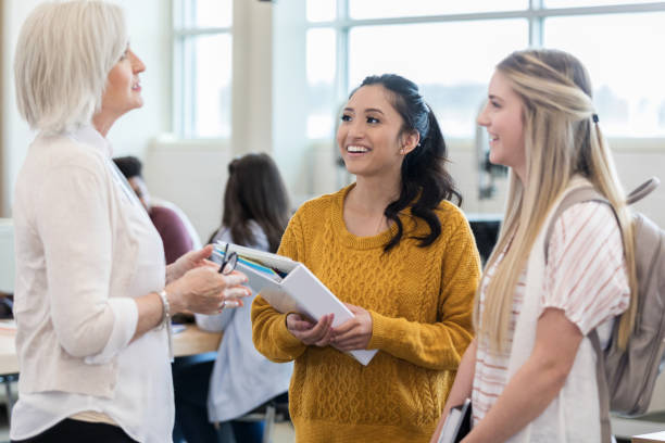 istock Female high school friends talk with teacher after class 1149898895