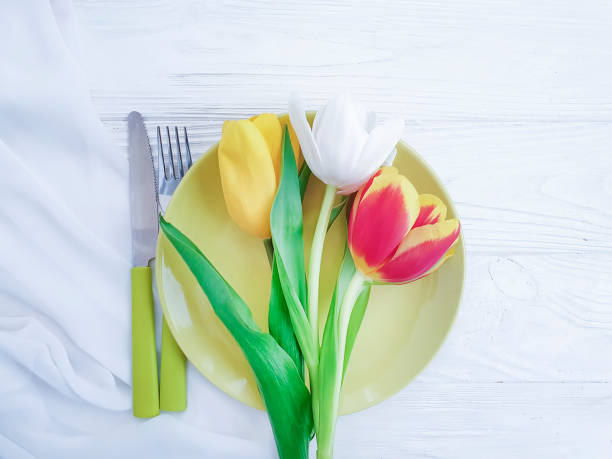 istock tulip flower plate on wooden background 1149898961