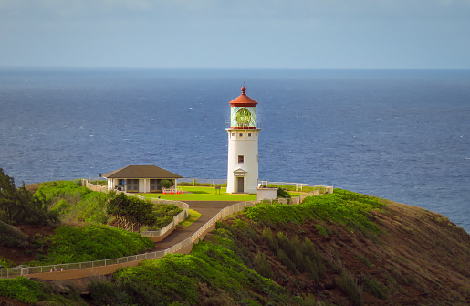 Kilauea Point Lighthouse glowing in the summer sun against a blue sky and ocean, Kauai, Hawaii, United States