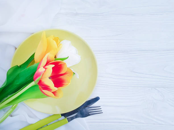 istock tulip flower plate on wooden background 1149907436