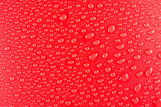 istock Droplets of water on a red, matte background illuminated with a delicate light. 1149907591