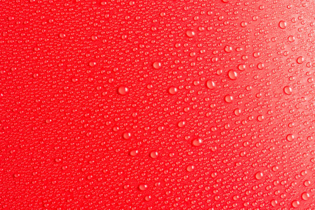 istock Droplets of water on a red, matte background illuminated with a delicate light. 1149907655