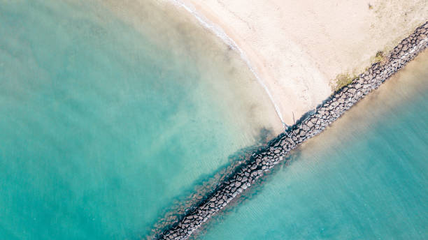 Geometric rock line and turquoise sea of Haleiwa Beach, North Shore Hawaii