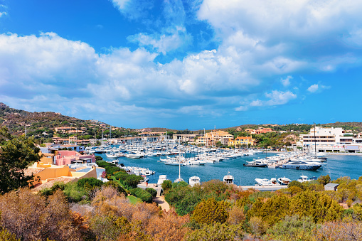 scenery with Marina and luxury yachts at Mediterranean Sea at Porto Cervo in Sardinia Island in Italy in summer. View on Sardinian town port with ships and boats in Sardegna.