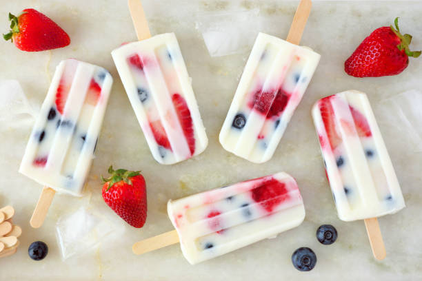 istock Summer strawberry blueberry yogurt popsicles, top view scattered on marble 1149915541