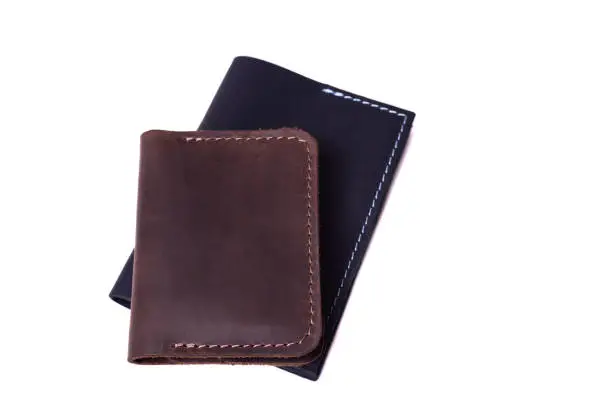 Handmade brown cardholder and black passport cover isolated on white background closeup. Stock photo of handmade luxury accessories.