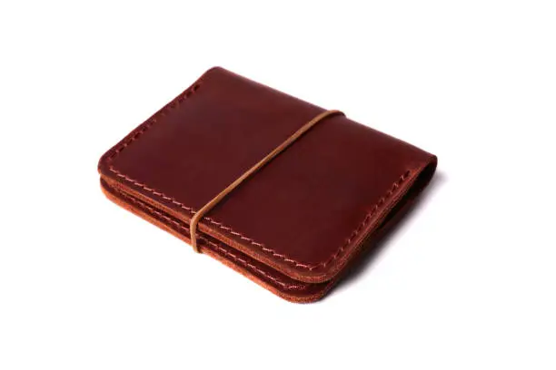 Handmade red color leather cardholder with rubber band isolated on white background closeup. Stock photo of handmade luxury accessories.
