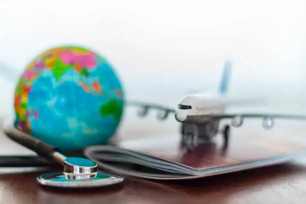 Photo of Healthcare and travel insurance concept. Stethoscope , passport document, airplane and globe