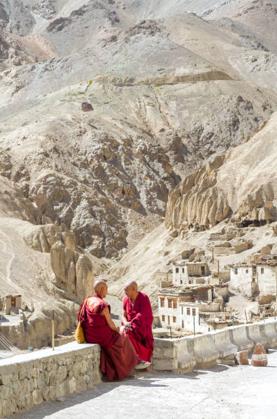 Two peaceful monks talk and rest during a break at the holy ceremony in the Buddhist monastery of Lamayuru stock photo