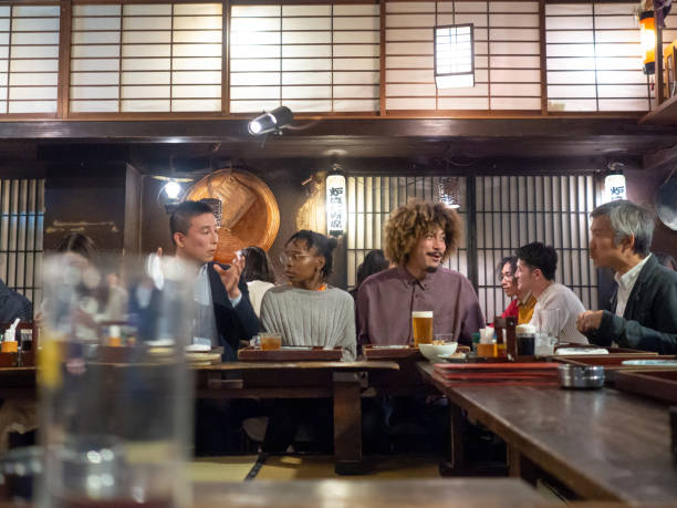 istock Young couple interacting with locals at Izakaya 1149925129