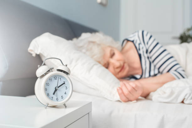 Grandma sleeping in bedroom. Deep sleep. Can not hear alarm Grandma sleeping in bedroom. Deep sleep. Can not hear alarm clock. Indoor, studio shoot, bedroom interior seniors sleeping routine stock pictures, royalty-free photos & images