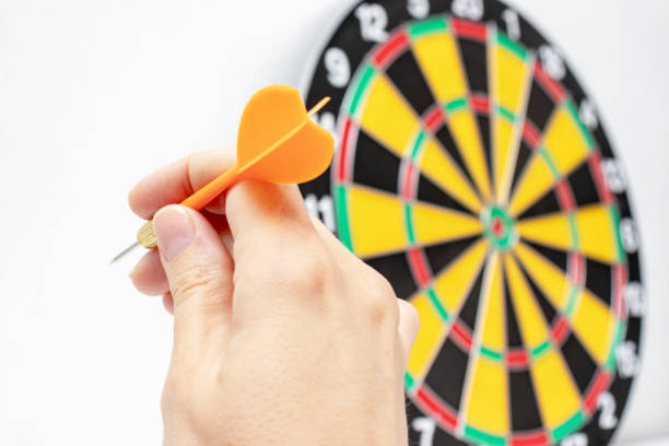 istock A hand holding a blue dart ready to throw it to a dartboard target, strategy and skill in business concept 1149933894
