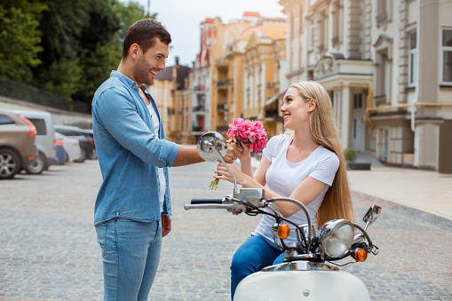 Young man and woman on scooter together date