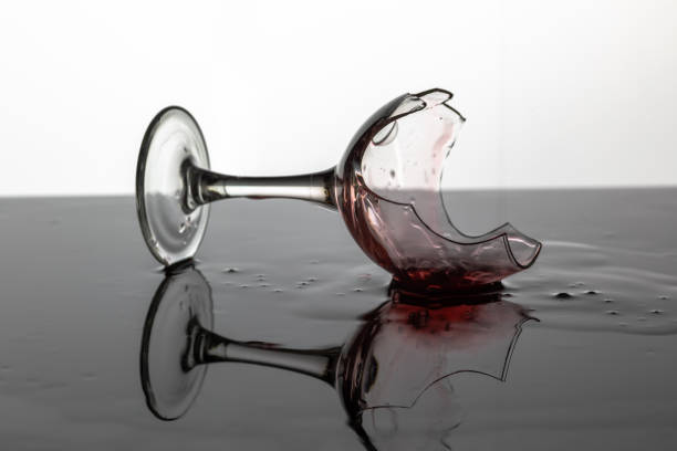 copa de vino rota con vino tinto que se pone sobre la superficie húmeda - glass broken spilling drink fotografías e imágenes de stock