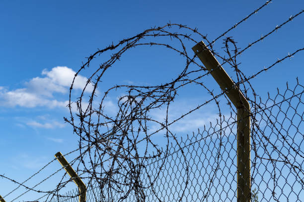 istock wire mesh fence deformed by immigrants at boundaries, 1149939254