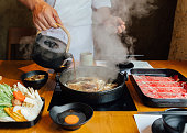 料理長は、タマネギ、キャベツ、ネギ、豆腐などの炒めた野菜に醤油を注ぎ、さらに、和牛の沸騰前に蒸し鍋に入れます。