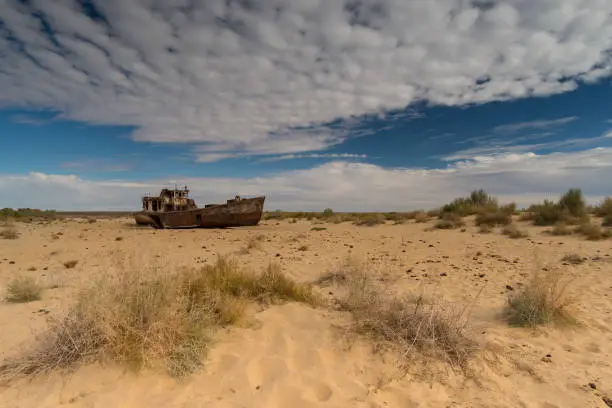 A rusted and abandoned ship is now in the sand, where once the Aral sea was.