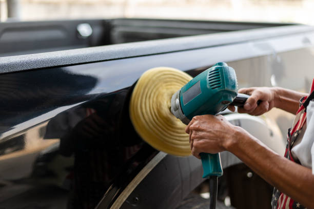 istock closeup hand man polishes a black car with a polisher with soft-focus and over light in the background 1149997607