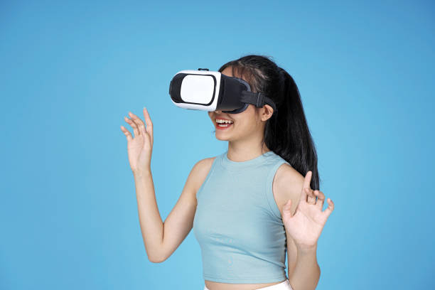 istock Asian young attractive beautiful young female student with 3D VR device on blue background 1149999605