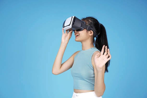 istock Asian young attractive beautiful young female student with 3D VR device on blue background 1149999611