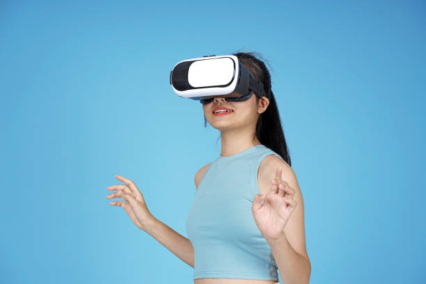 istock Asian young attractive beautiful young female student with 3D VR device on blue background 1149999614