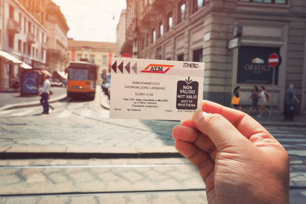 street view showing public transport ticket on hand in Milan city surround by vintage building and tram on background, Italy Italy - 22 June 2018: street view showing public transport ticket on hand in Milan city surround by vintage building and tram on background, Italy cash in transit vehicle stock pictures, royalty-free photos & images