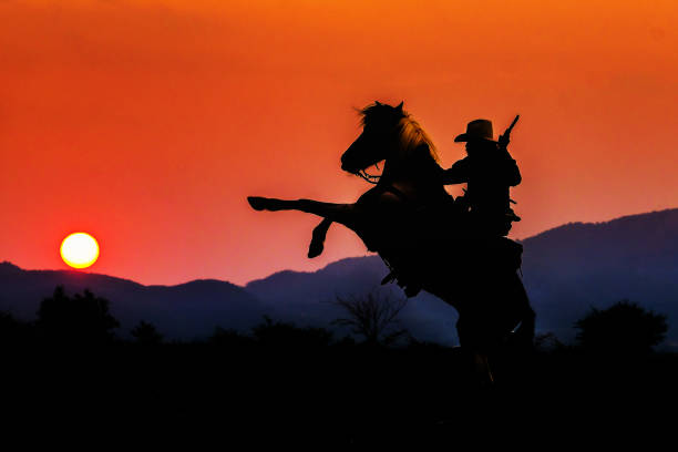 istock Cowboy silhouette on a horse during nice sunset 1150013755