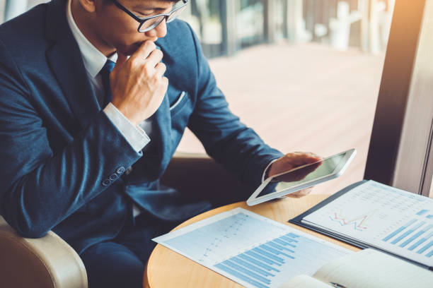 homem de negócios que trabalha e que usa a tabuleta de digitas investimento novo do projeto financeiro no café coffee. - gerente de banco - fotografias e filmes do acervo