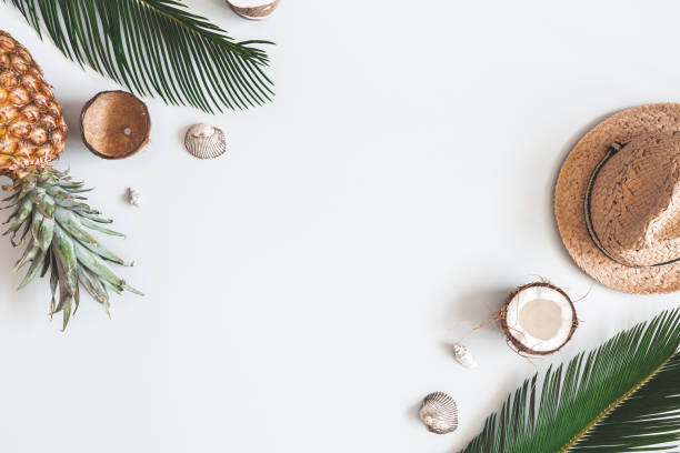 istock Summer composition. Tropical palm leaves, hat, coconut, pineapple on pastel gray background. Summer concept. Flat lay, top view, copy space 1150021124