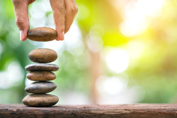istock Banlance stones for spa with hand holding stone on abstract bokeh background 1150021213