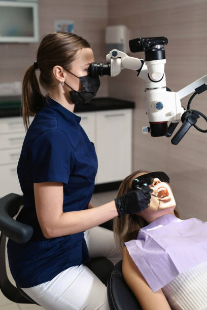 istock Doctor making teeth examination research survey using microscope in dentistry. Dentist is treating patient in modern dental office. 1150025867