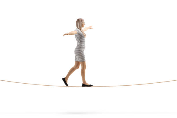 istock Young blond woman walking on a rope with arms spread 1150026210