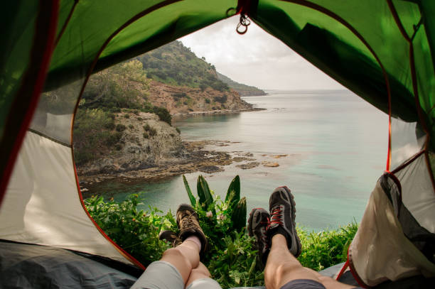 istock Man and woman looking at mountains from tent 1150026953