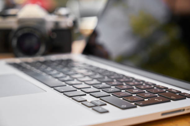 istock laptop and retro camera on the table 1150026984