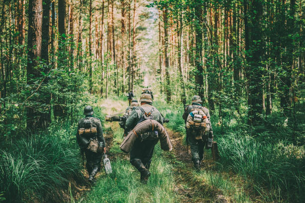 istock Rear View Of People Walking Amidst Trees In Forest 1150030906