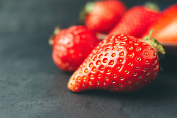 istock Red strawberry on the dark background close up view 1150031959