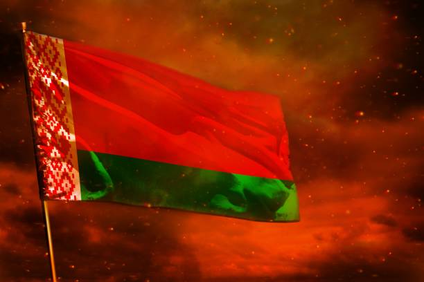 istock Fluttering Belarus flag on crimson red sky with smoke pillars background. Troubles concept. 1150040683