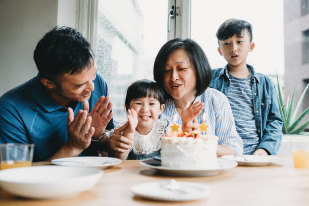 family celebrating the birthday of the little daughter together - little cakes imagens e fotografias de stock