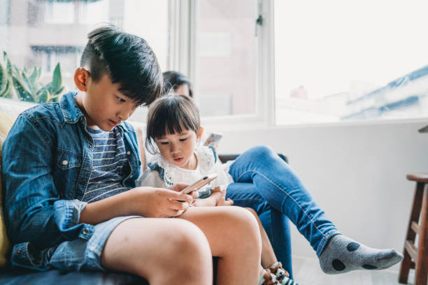 istock Family using a mobile phone together sitting on the sofa at home 1150041867