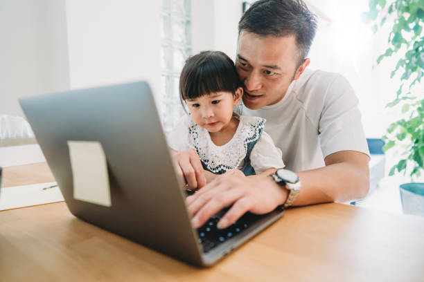 istock Father and daughter working together at home 1150041877