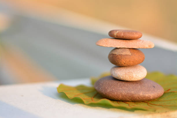 istock Zen stones put on lotus leaf with sunlight left space position. 1150043330